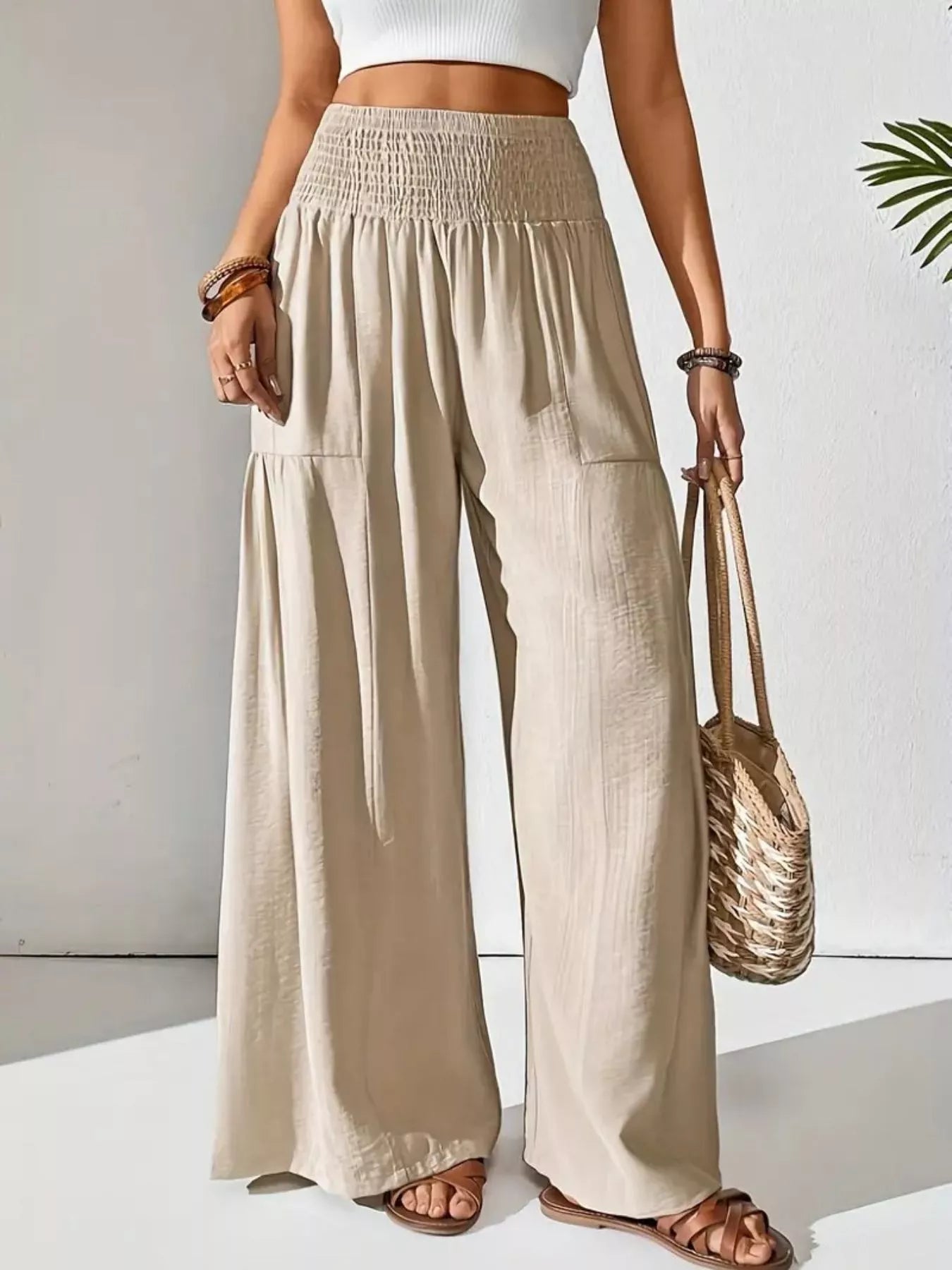 Collection of different pants styles laid out showing wide leg pants, distressed jeans, and various cuts