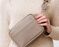 Black leather wide strap crossbody bag worn across the body