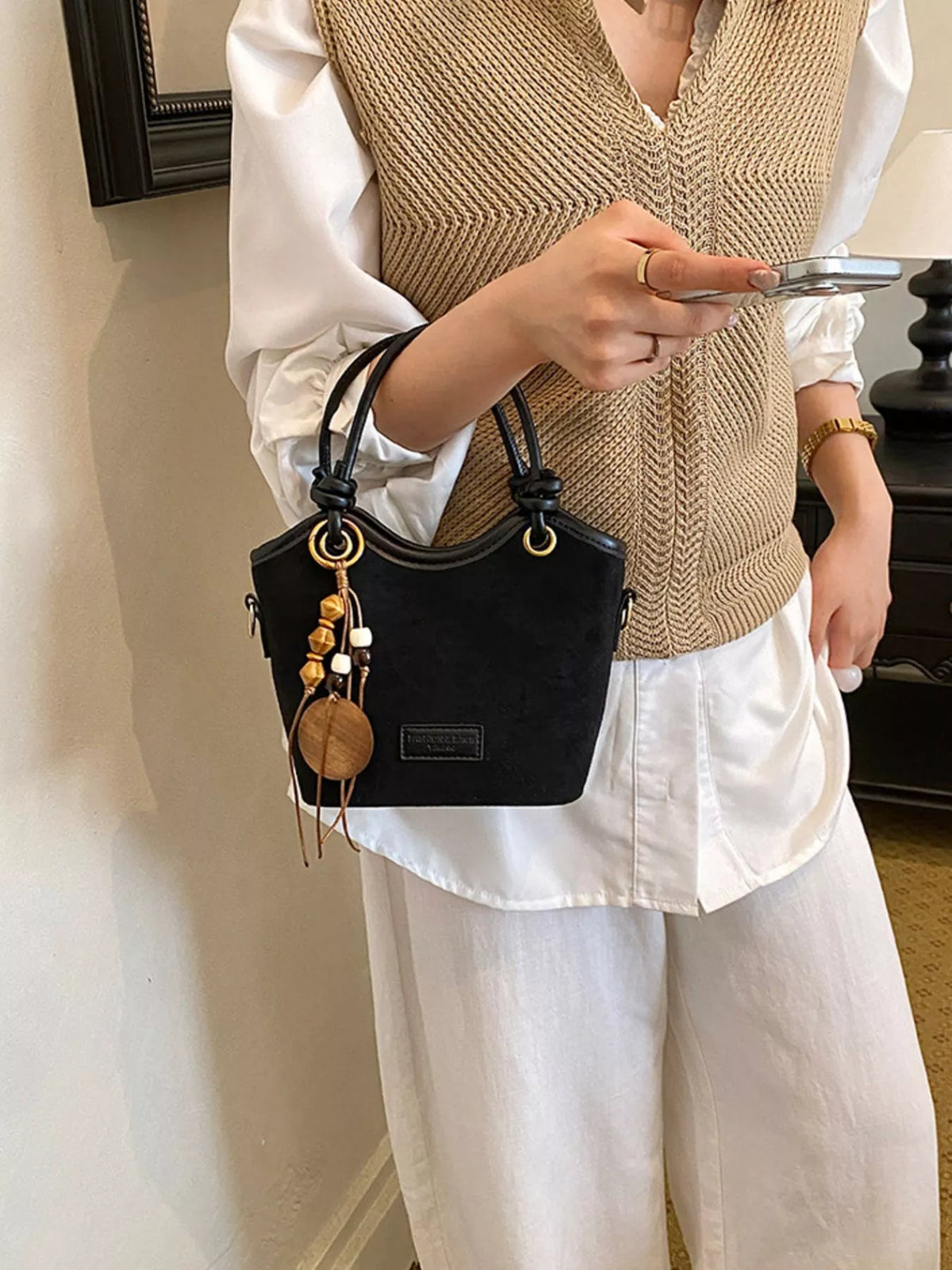 suede crossbody bag with decorative wooden bead charm | dropsona - neutral - close-up detail
